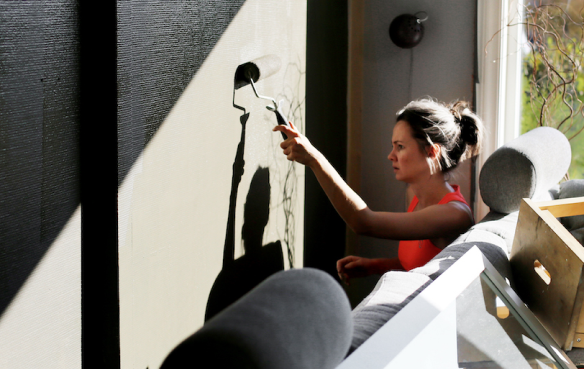 Kvinne maler vegg i stue. Foto Carl Martin Nordby